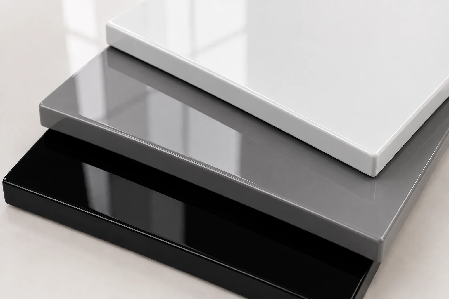 Layered high-gloss panel samples in polished white, grey and charcoal