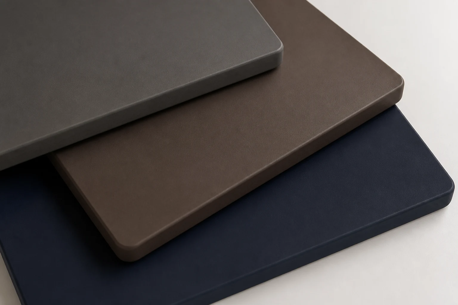 Layered matte spray panel samples in charcoal, umber and deep blue