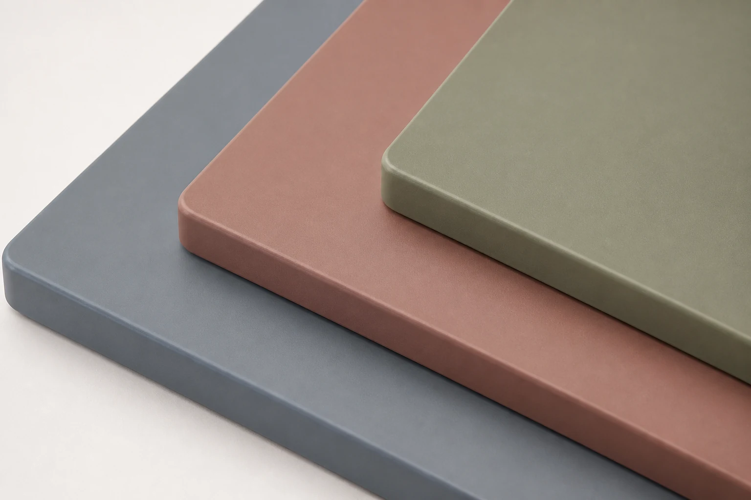 Layered matte spray panel samples in muted blue, clay and sage